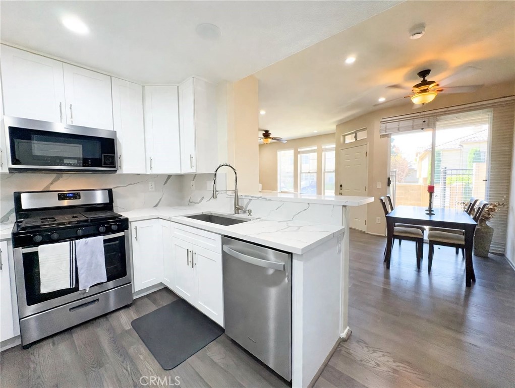 This chef-inspired kitchen features crisp white shaker cabinets, dramatic quartz counters with waterfall edge, stainless - 29 Waxwing, Aliso Viejo CA 92656 - photo 3