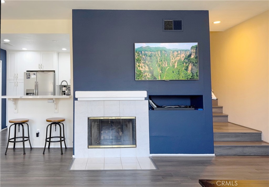 Cozy living room anchored by a tiled fireplace and bold navy feature wall with built-in media niche. Open to the updated - 29 Waxwing, Aliso Viejo CA 92656 - photo 6