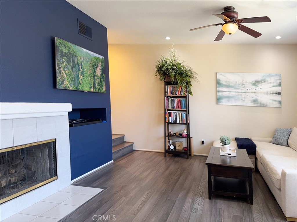 Warm and welcoming living room centered on a cozy fireplace with designer navy accent wall and mounted TV. Features wood - 29 Waxwing, Aliso Viejo CA 92656 - photo 7