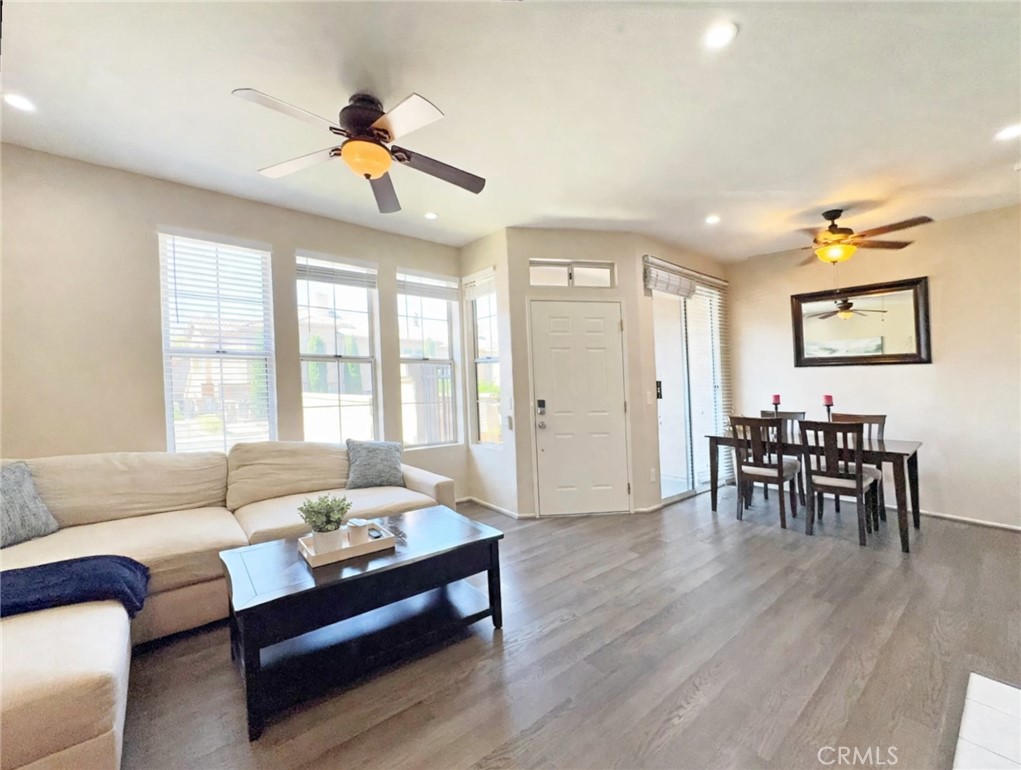 Bright, open living and dining combo flooded with natural light from a wall of windows. Wood-look floors, dual ceiling f - 29 Waxwing, Aliso Viejo CA 92656 - photo 9