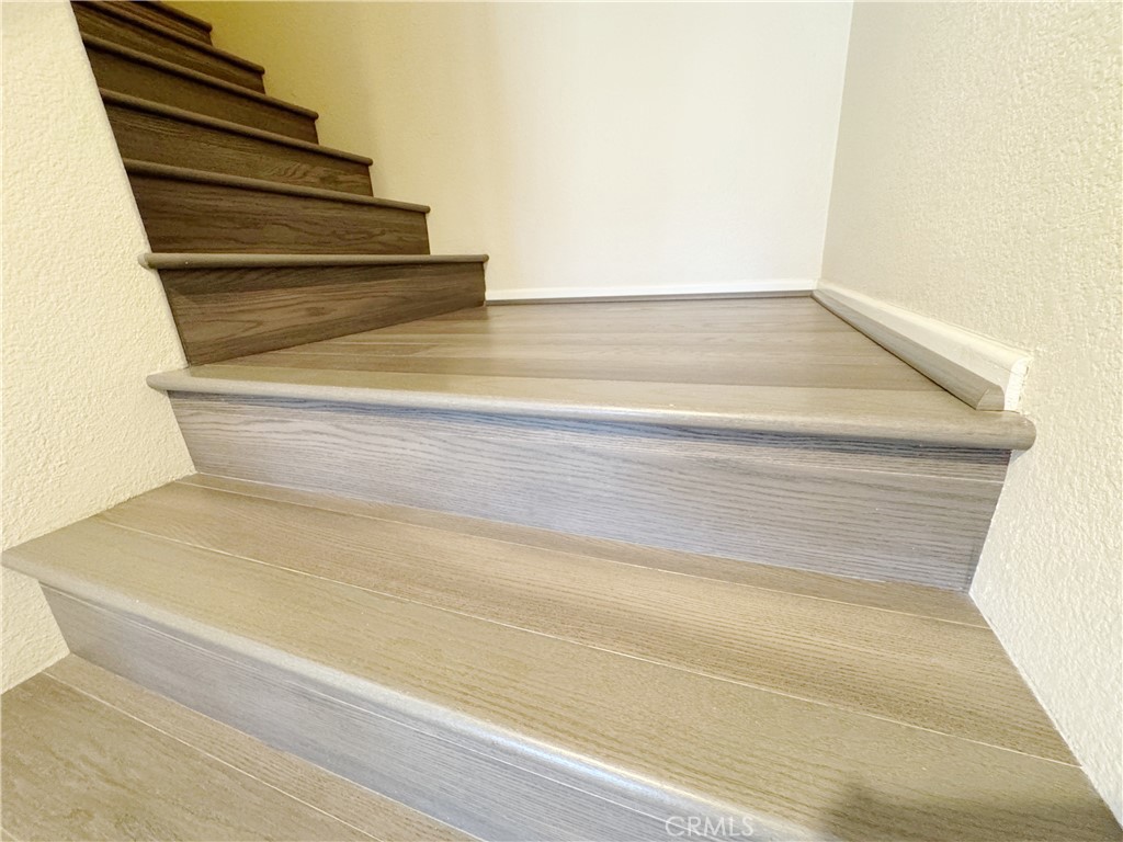 Updated staircase featuring modern wood-look flooring with clean, crisp lines and bright neutral walls — a stylish, low- - 29 Waxwing, Aliso Viejo CA 92656 - photo 11