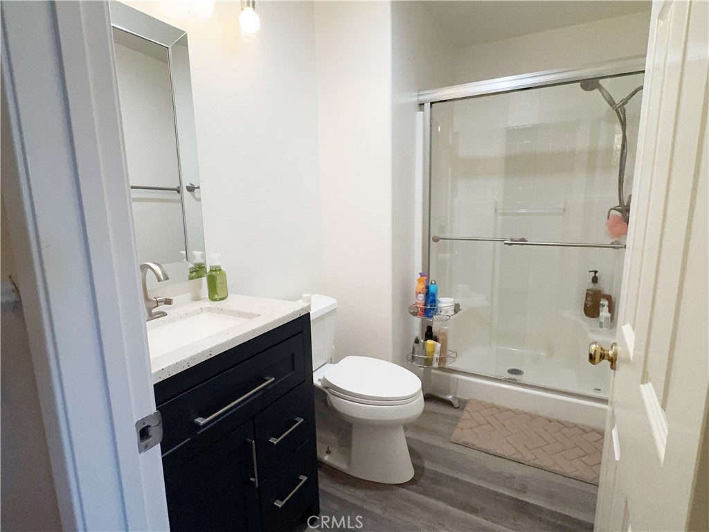 Updated powder bath with modern dark vanity, white integrated sink, designer frame mirror and lighting, and wood-look fl - 29 Waxwing, Aliso Viejo CA 92656 - photo 13