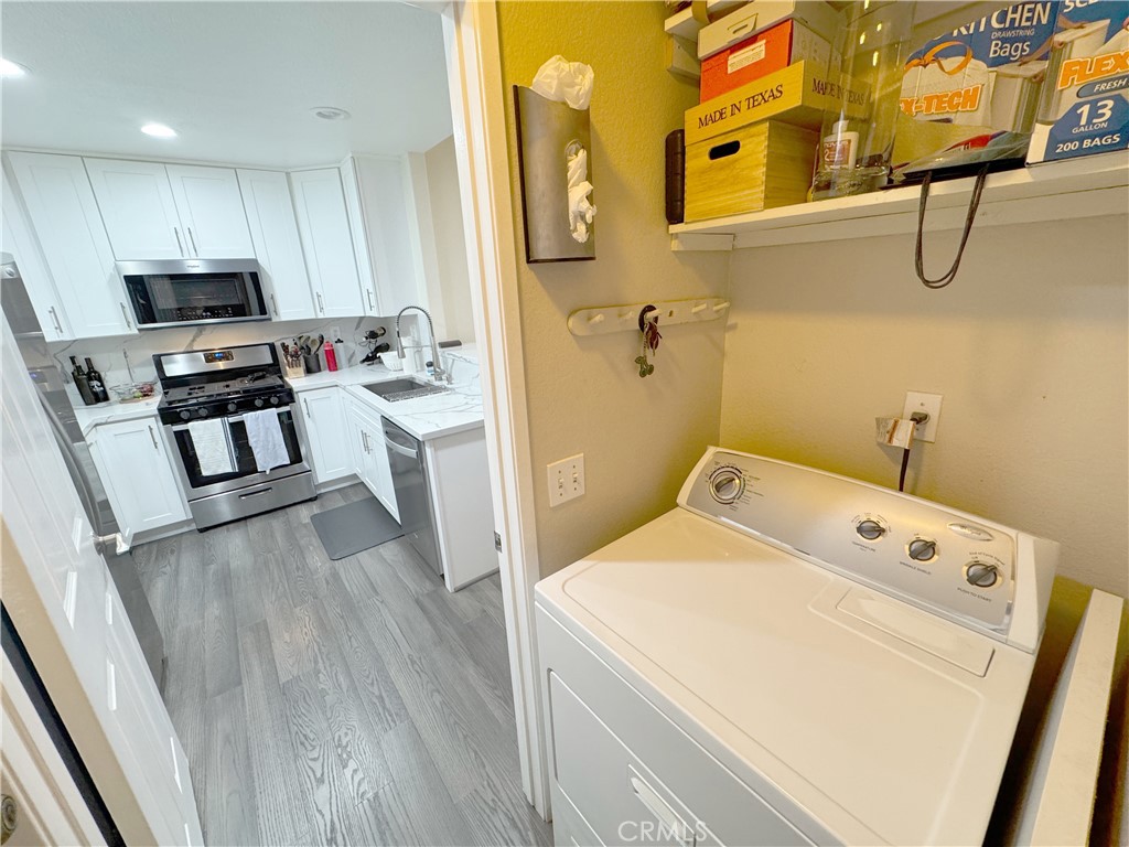 Functional laundry flowing to fully updated kitchen with white shaker cabinets, quartz counters, and stainless appliance - 29 Waxwing, Aliso Viejo CA 92656 - photo 25