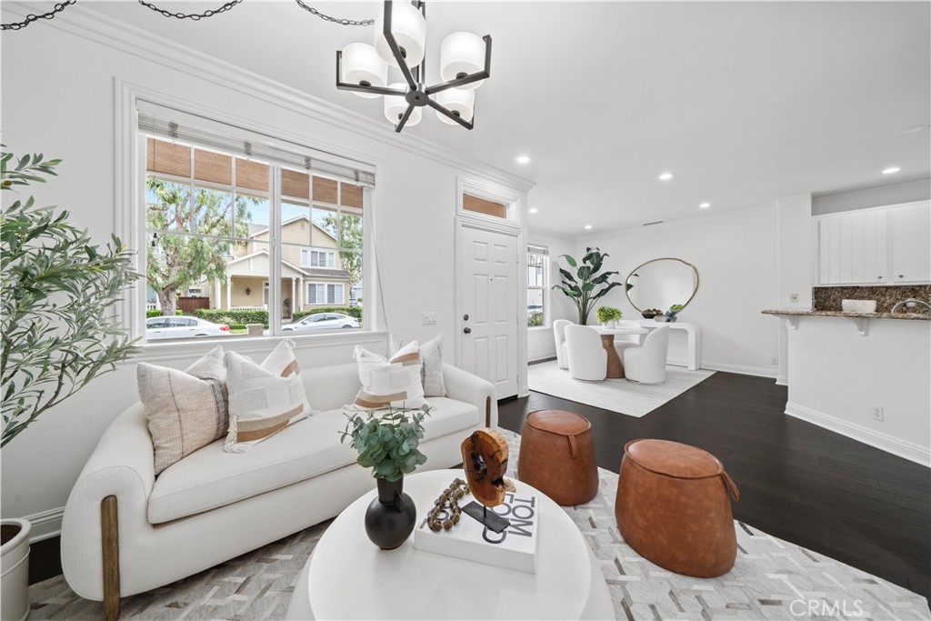 Living room with fireplace and accent lighting shows espresso wood floors and crown molding. - 50 Bluff Cove Drive, Aliso Viejo CA 92656 - photo 1