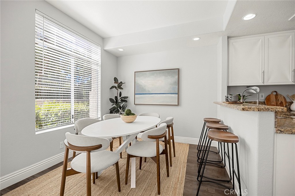 The open-concept dining area flows seamlessly into the kitchen and features a breakfast bar with additional seating, mak - 66 Cinnamon Teal, Aliso Viejo CA 92656 - photo 10