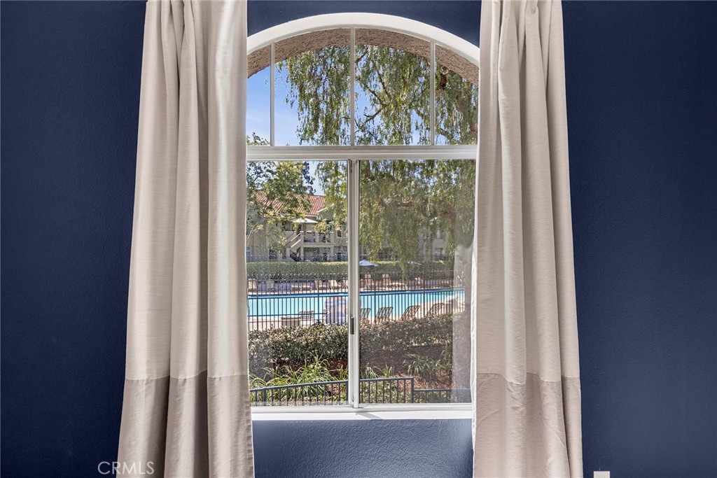 One of the highlights of the primary suite is its oversized arched window, framing peaceful views of the community pool - 66 Cinnamon Teal, Aliso Viejo CA 92656 - photo 21