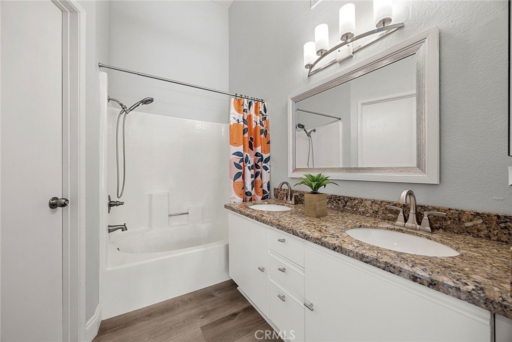 The spacious primary bathroom features a dual-sink vanity with granite countertops, plenty of cabinet storage, and a soa - 66 Cinnamon Teal, Aliso Viejo CA 92656 - photo 24