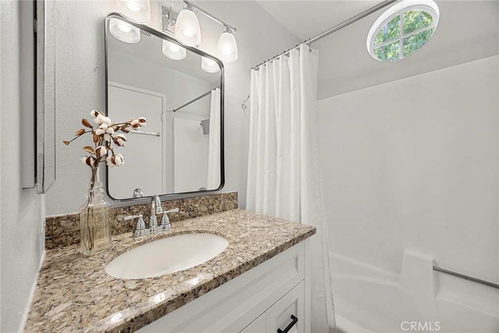 The secondary suite includes its own private bathroom featuring granite countertops, updated cabinetry, a tub/shower com - 66 Cinnamon Teal, Aliso Viejo CA 92656 - photo 29