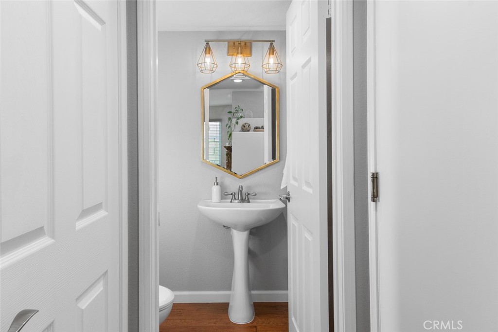 Half Bath Downstairs with simple Pedestal Sink and Gold Accent Mirror with Lighting, plus a hall coat closet - 9 Sequoia, Aliso Viejo CA 92656 - photo 6