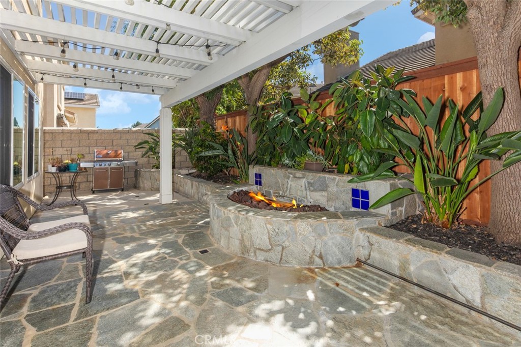 Built-in Gas Fire Place and shade structure paired with mature landscaping make this backyard extra inviting - 9 Sequoia, Aliso Viejo CA 92656 - photo 14