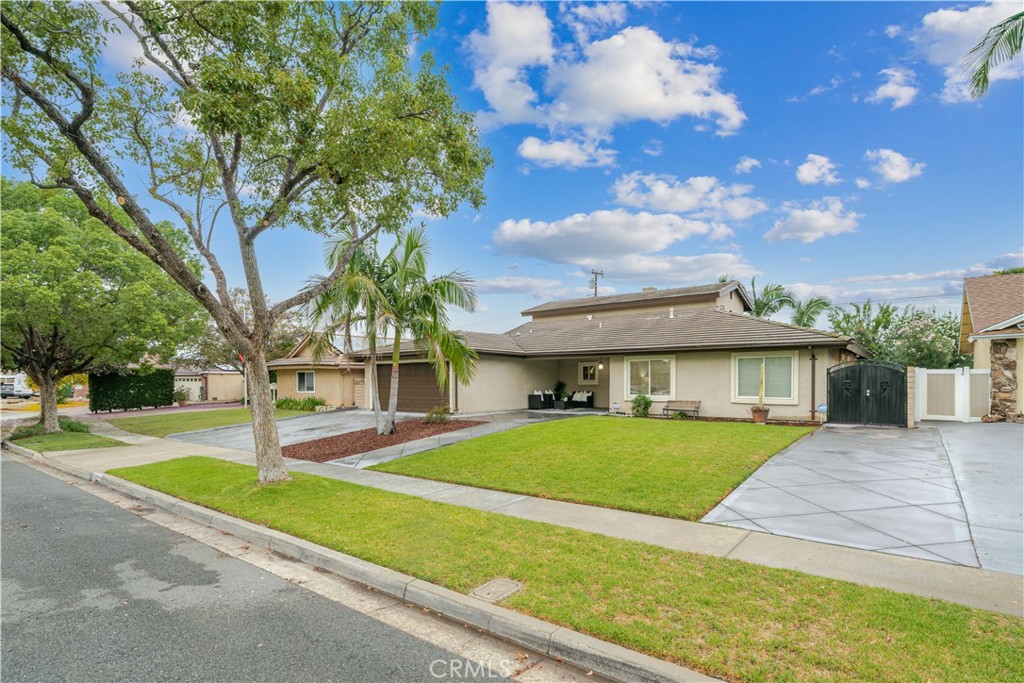 Viewed from an angle, the home’s broad frontage highlights its generous lawn, mature trees, and established landscaping. - 148 N Jerrilee Lane, Anaheim Hills CA 92807 - photo 1