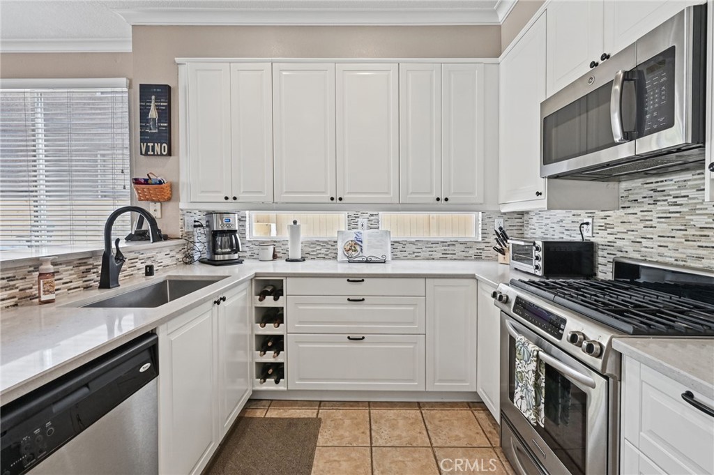 Remodeled kitchen has soft close drawers and cabinets and SS appliances. Notice the built in wine cabinet. - 1028 S Brianna Way, Anaheim CA 92808 - photo 15