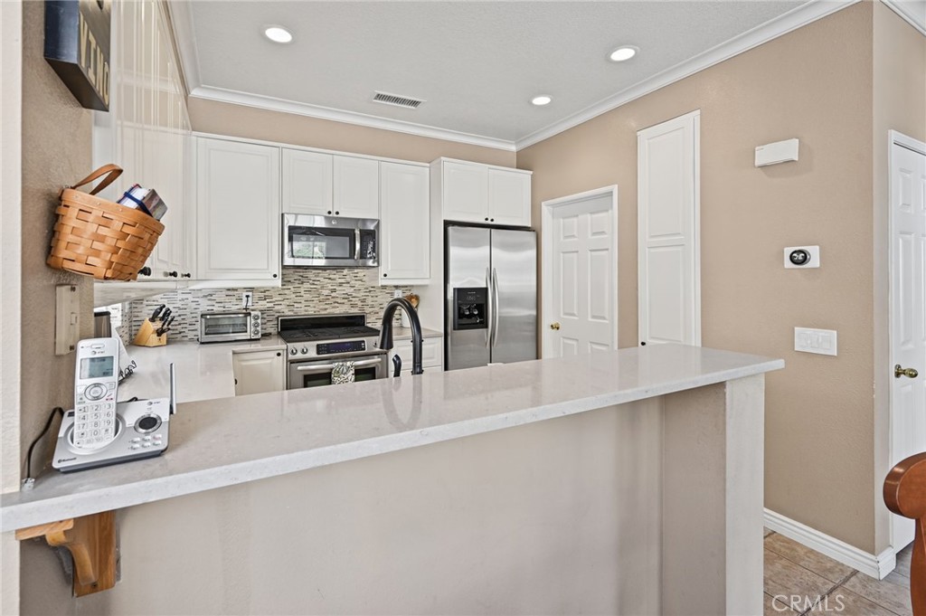 The remodeled kitchen has quartz countertops and room for seating at the breakfast bar - 1028 S Brianna Way, Anaheim CA 92808 - photo 17