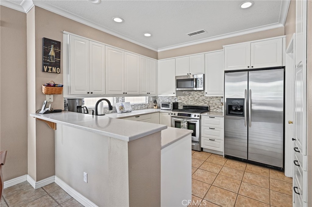 The remodeled kitchen has quartz countertops and room for seating at the breakfast bar - 1028 S Brianna Way, Anaheim CA 92808 - photo 19