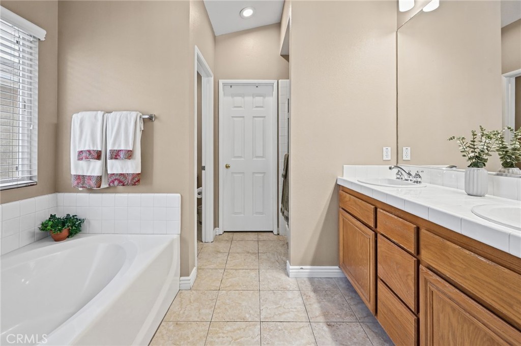 Primary Bathroom has a Double Vanity, Soaking Tub, Separate Walk in Shower and large Walk in Closet - 1028 S Brianna Way, Anaheim CA 92808 - photo 32