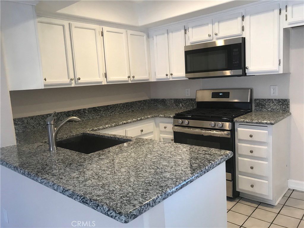 Remodeled kitchen with granite island style counter top, open look style. - 2643 W Cameron Court 218, Anaheim CA 92801 - photo 1