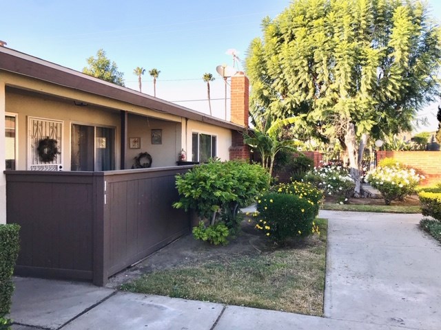 Exterior view of unit with grass, trees and foliage in bloom. - 9166 Cerritos Avenue 11, Anaheim CA 92804 - photo 1