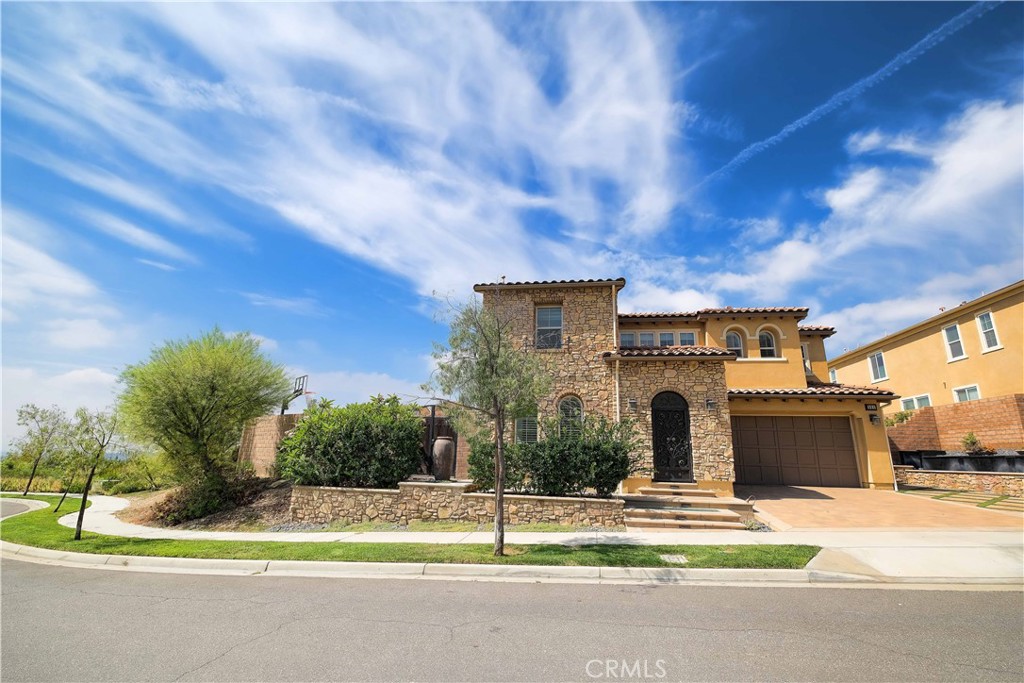Welcoming street view of this two-story home with landscaped grounds and distinctive architectural details. - 551 SAN ARDO, Brea CA 92821 - photo 1