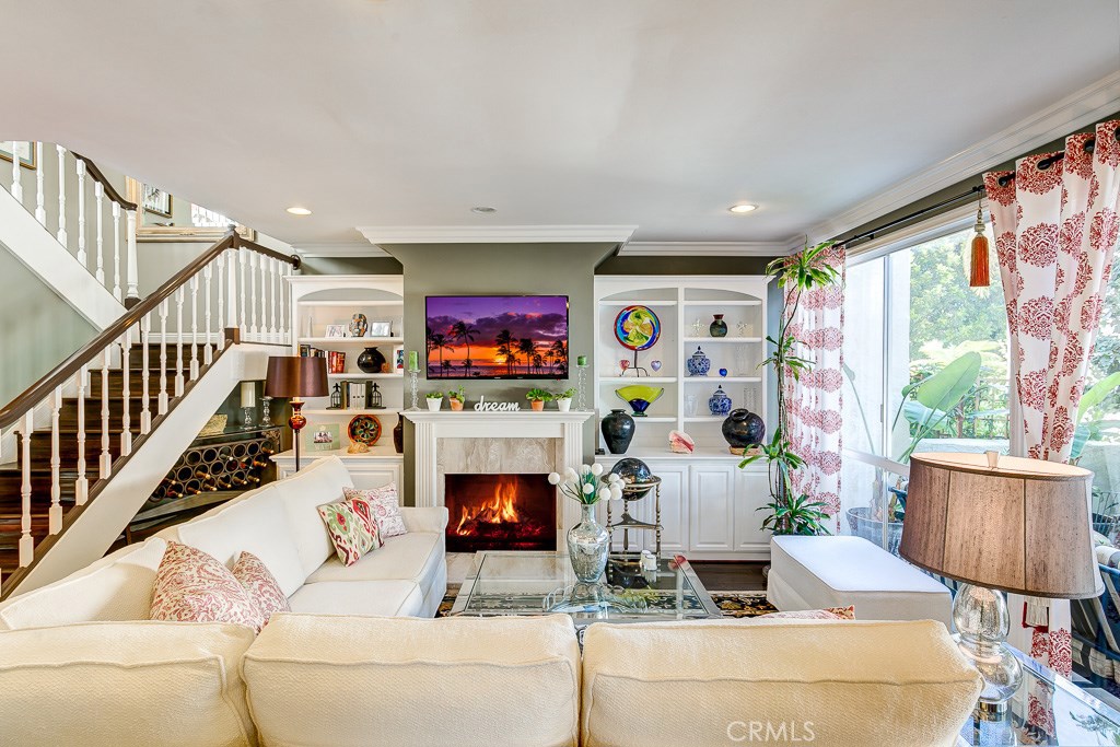 Inviting living room with gas fireplace and access to back patio. - 19 Canyon Crest Drive 25, Corona Del Mar CA 92625 - photo 1