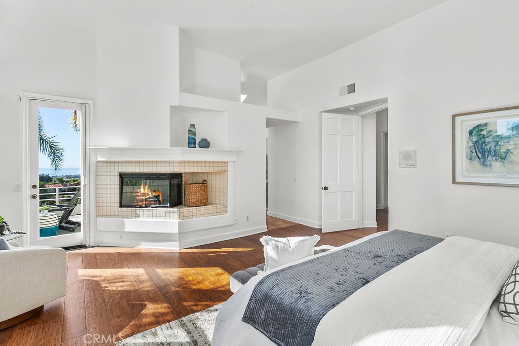 Corner fireplace and access to ocean view balcony, plus a sitting area in your ensuite primary bedroom. Fire in fireplac - 19 Harbor Pointe, Corona Del Mar CA 92625 - photo 10