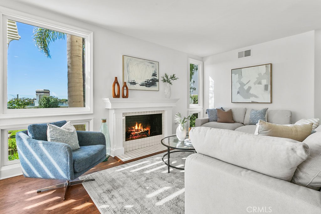 View windows in family room. Fire in fireplace is virtually created. - 19 Harbor Pointe, Corona Del Mar CA 92625 - photo 18