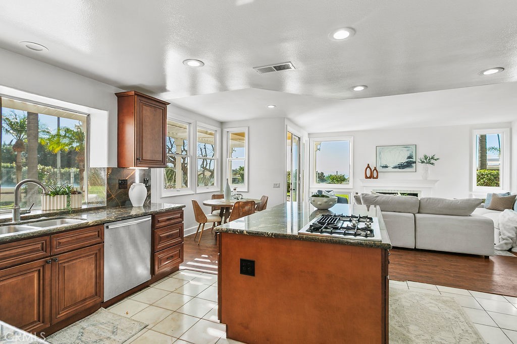 View from kitchen to outdoors and family room. Note that cooktop is down vented so the openness and view are not obtruct - 19 Harbor Pointe, Corona Del Mar CA 92625 - photo 23