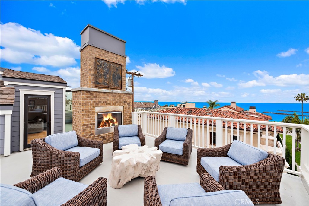 Roof top ocean view deck 1 with chairs. and fireplace. - 212 Marguerite Avenue, Corona Del Mar CA 92625 - photo 3