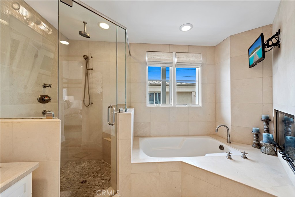Primary suite has a spa-like bathroom with tub and fireplace. - 212 Marguerite Avenue, Corona Del Mar CA 92625 - photo 17