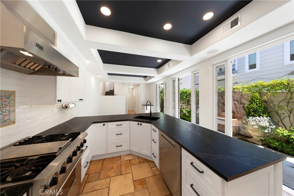 Kitchen flows to a private side patio with three-french door access, retractable awning and fountain, with adjoining fam - 515 Begonia Avenue B, Corona Del Mar CA 92625 - photo 1