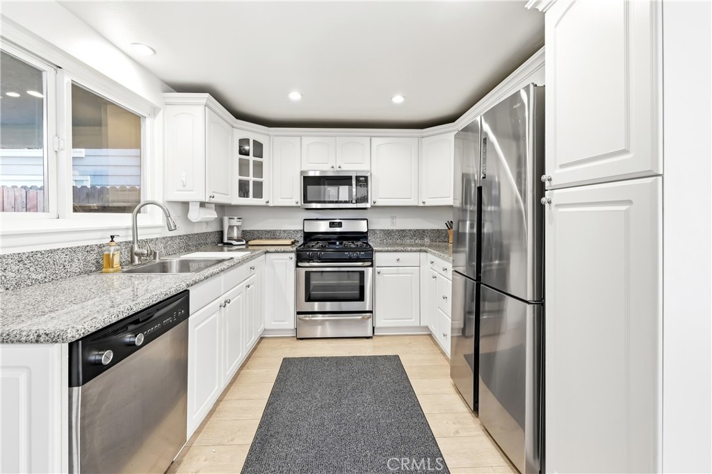 A well appointed kitchen with granite countertops, new gas stovetop and oven below, all stainless steel newer appliances - 602 602.5 Marguerite 2, Corona Del Mar CA 92625 - photo 10