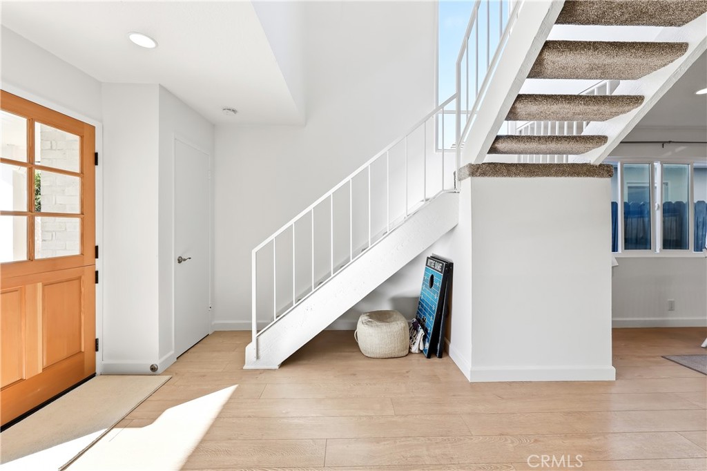 The staircase has new carpeting and storage below, plus there is a coat closet at the base of the staircase. - 602 602.5 Marguerite 2, Corona Del Mar CA 92625 - photo 11