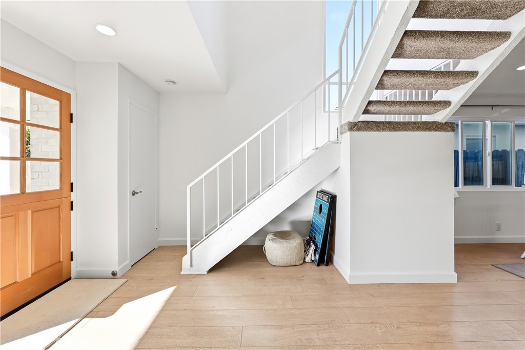 The staircase has new carpeting and storage below, plus there is a coat closet at the base of the staircase. - 602 602.5 Marguerite 2, Corona Del Mar CA 92625 - photo 11
