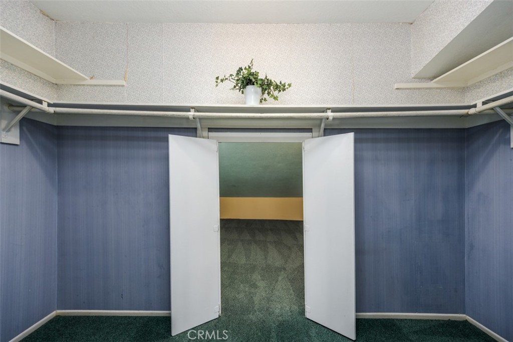 2nd primary bedroom walk in closet, access to playroom - 1828 Kinglet Court, Costa Mesa CA 92626 - photo 31