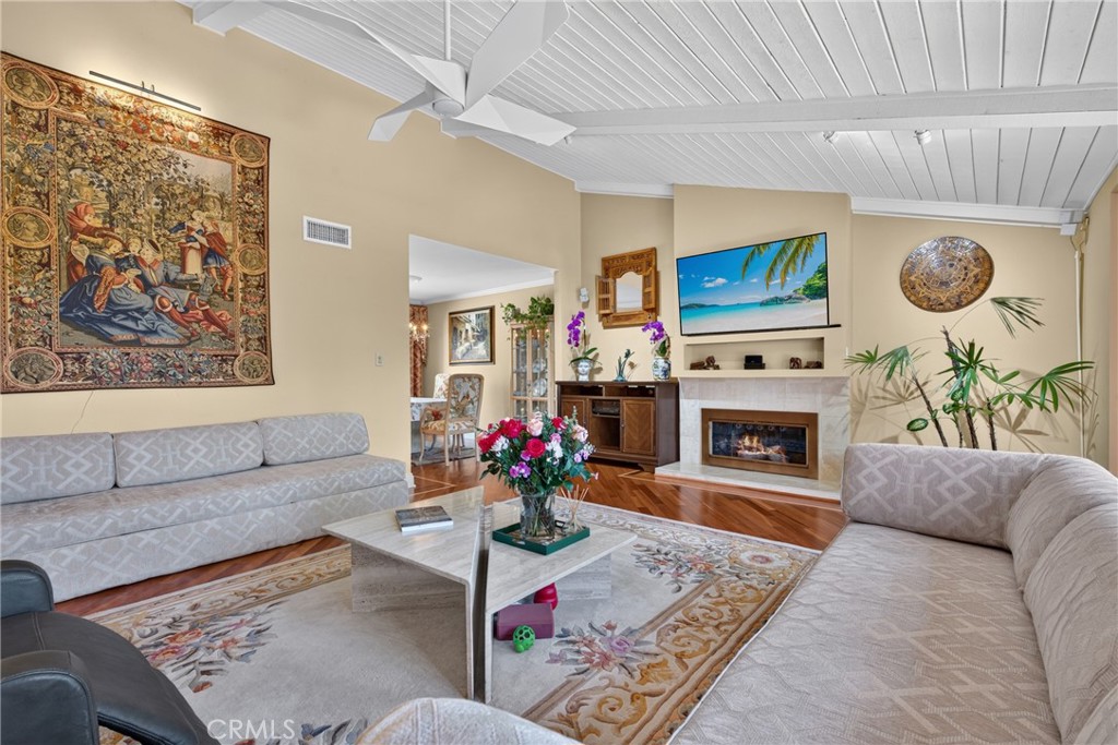 Vaulted living room with beamed ceiling and ceiling fan and fireplace - 2740 Cardinal Drive, Costa Mesa CA 92626 - photo 11