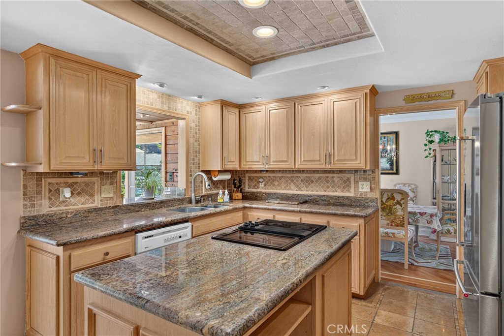 Beautiful wood cabinetry kitchen with granite countertops and mosaic backsplash, island with cooktop, stainless steel si - 2740 Cardinal Drive, Costa Mesa CA 92626 - photo 15