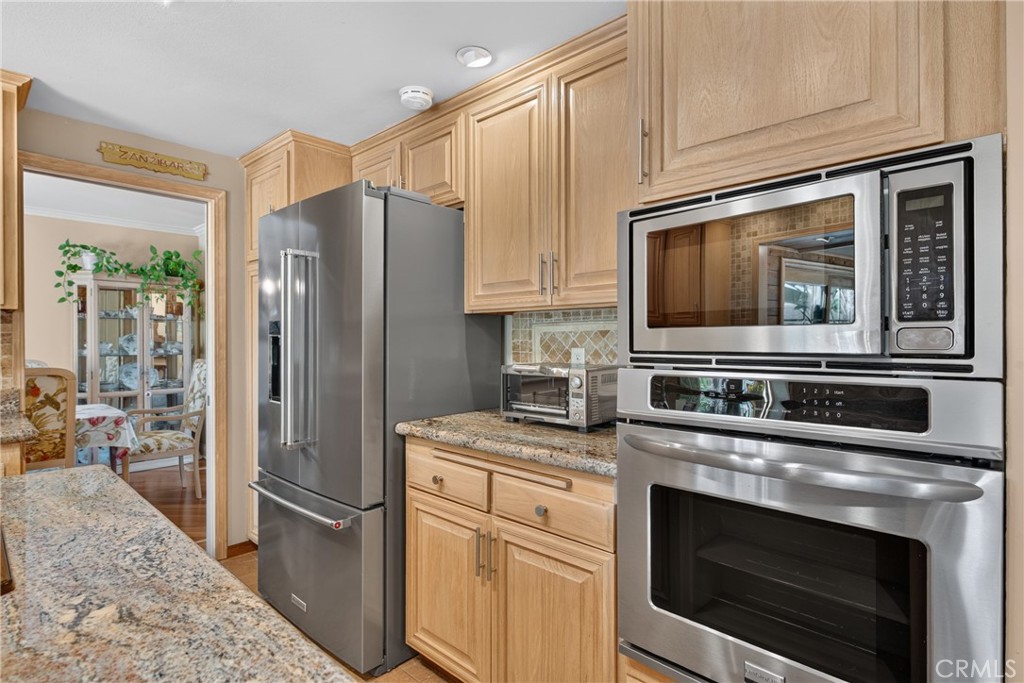 Beautiful wood cabinetry kitchen with granite countertops and mosaic backsplash, island with cooktop, stainless steel si - 2740 Cardinal Drive, Costa Mesa CA 92626 - photo 16