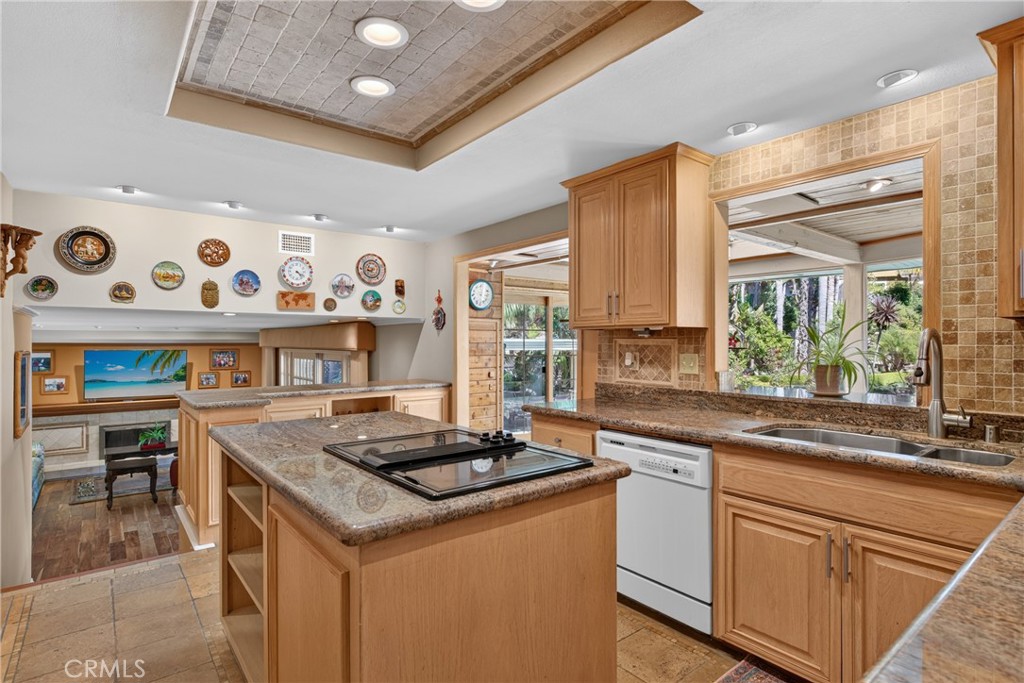 Beautiful wood cabinetry kitchen with granite countertops and mosaic backsplash, island with cooktop, stainless steel si - 2740 Cardinal Drive, Costa Mesa CA 92626 - photo 19
