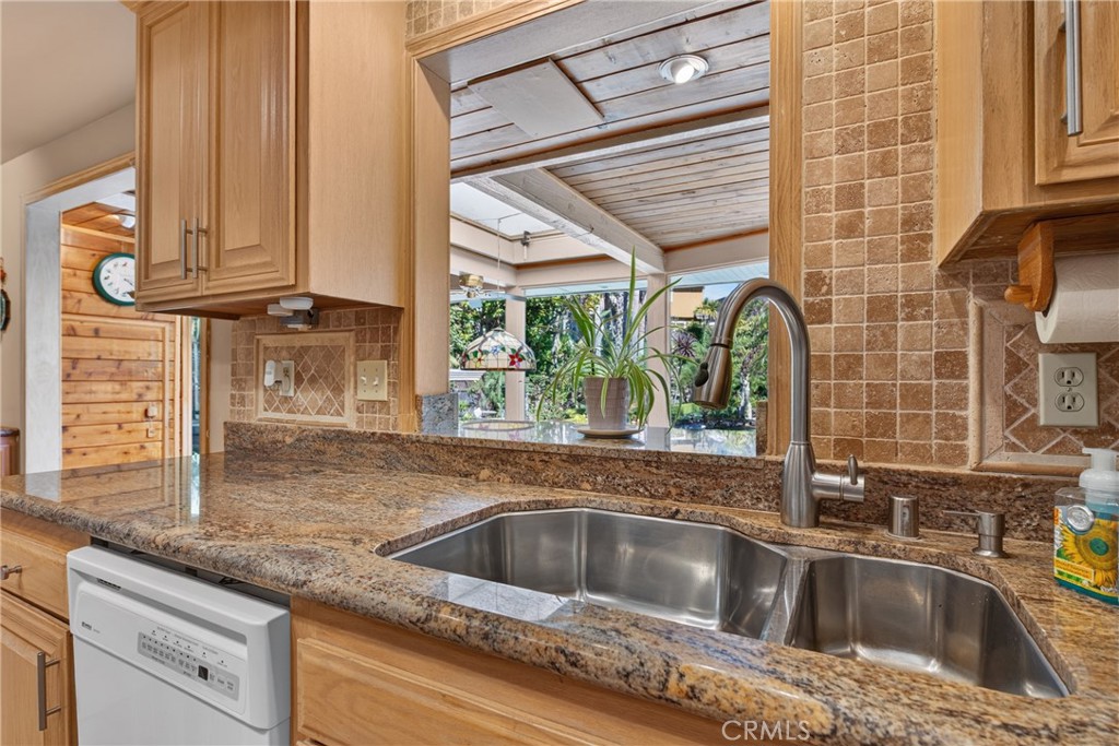 Beautiful wood cabinetry kitchen with granite countertops and mosaic backsplash, island with cooktop, stainless steel si - 2740 Cardinal Drive, Costa Mesa CA 92626 - photo 21