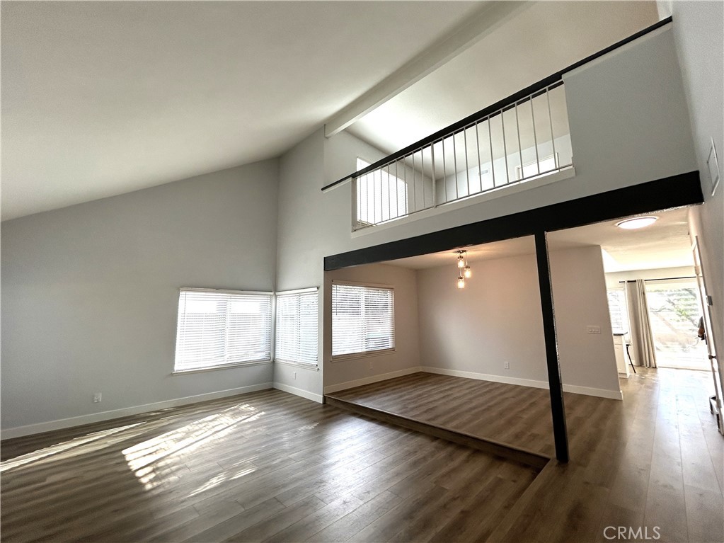 Soaring ceilings and an open loft add to the living room’s spacious feel - 3475 Fuchsia, Costa Mesa CA 92626 - photo 6