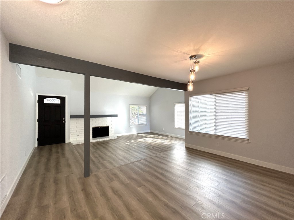 Light-filled living room with a fireplace and adjacent dining area - 3475 Fuchsia, Costa Mesa CA 92626 - photo 7