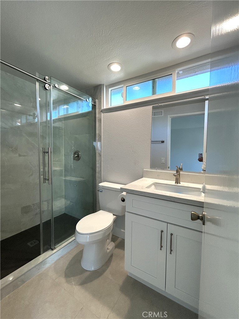 Updated primary bathroom with a glass-enclosed shower - 3475 Fuchsia, Costa Mesa CA 92626 - photo 12
