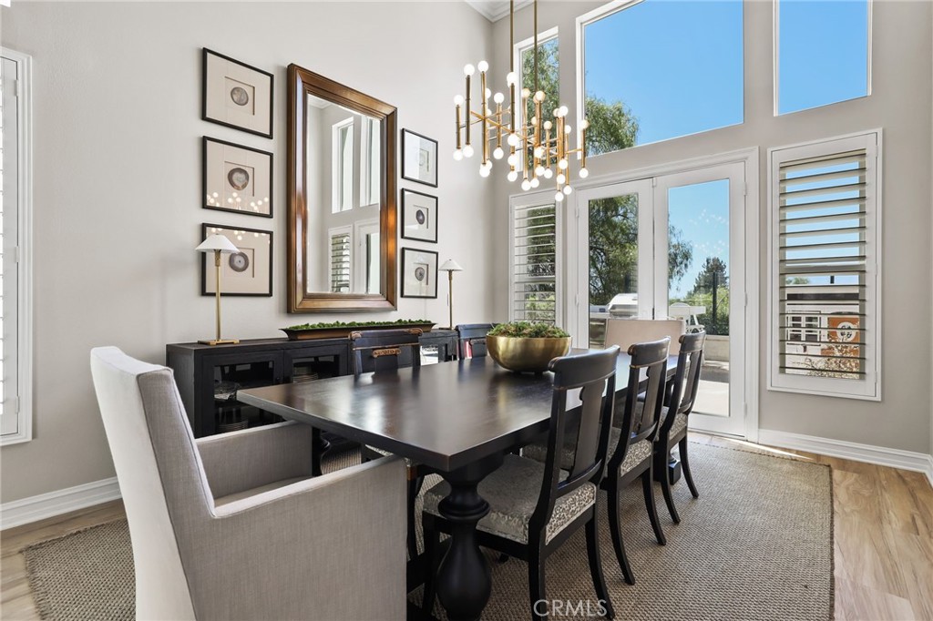 Stunning formal dining room featuring a custom light fixture and French doors that provide abundant natural light. - 5 Mountain Gate, Coto de Caza CA 92679 - photo 5