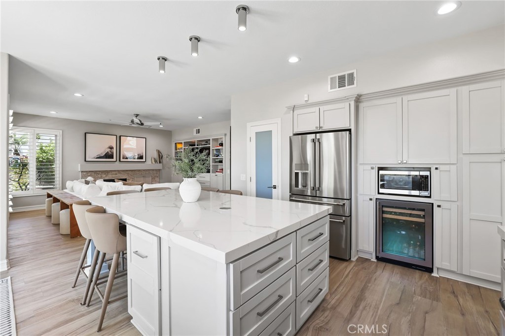 Tastefully updated kitchen with a breakfast bar, wine frig, and seamlessly flows into a spacious great room - 5 Mountain Gate, Coto de Caza CA 92679 - photo 12