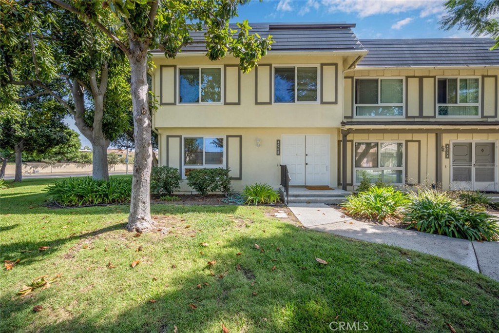 Front Exterior – Inviting two-story townhome with a charming façade featuring crisp trim, large dual-pane windows, and a - 4068 Avenida Sevilla, Cypress CA 90630 - photo 1