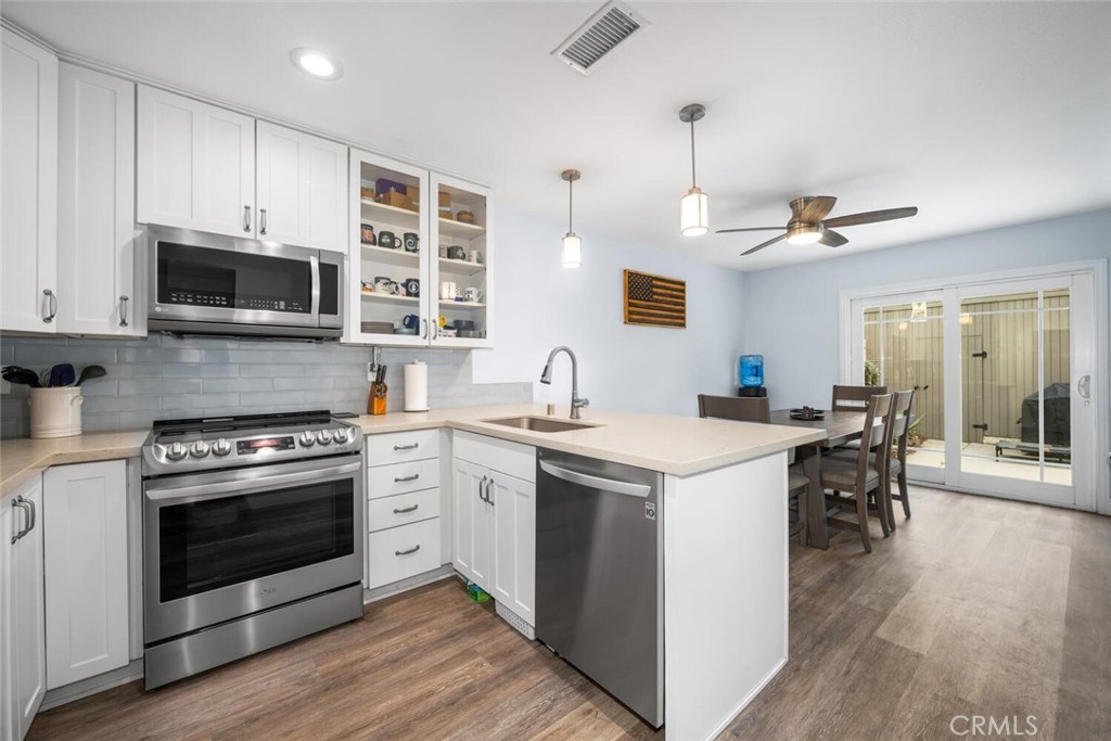 Kitchen & Dining Area – Open-concept design connecting the kitchen to the dining space, featuring pendant lighting, a ce - 4112 Avenida Sevilla, Cypress CA 90630 - photo 1