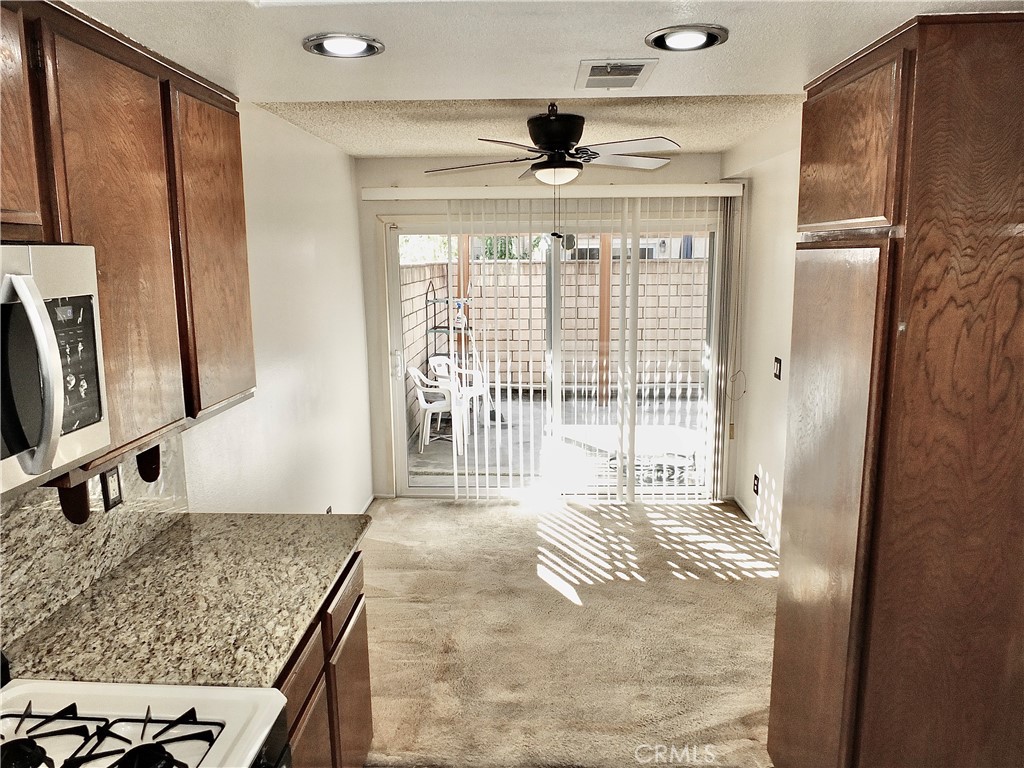 Dining nook adjacent to kitchen and sliding door out to a large patio. - 8485 Kington Way 11, Cypress CA 90630 - photo 5
