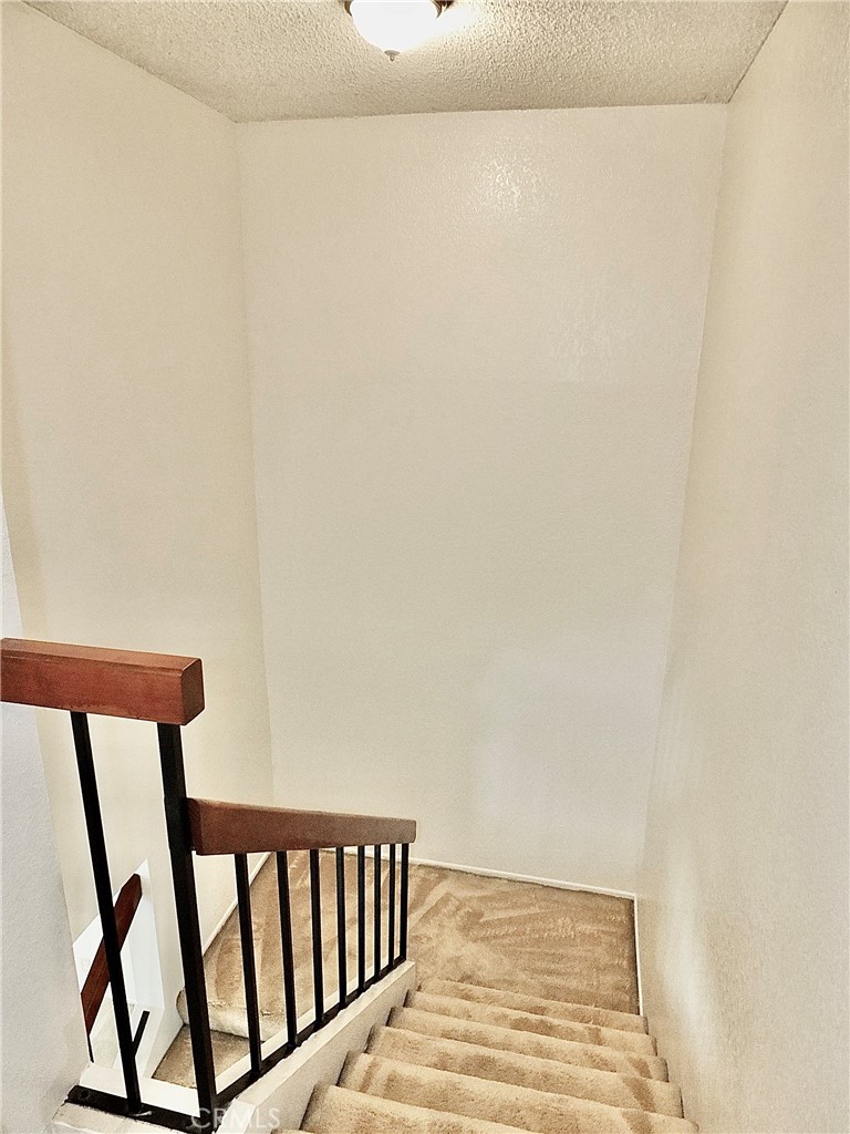 The landing to the top of the stair. - 8485 Kington Way 11, Cypress CA 90630 - photo 14