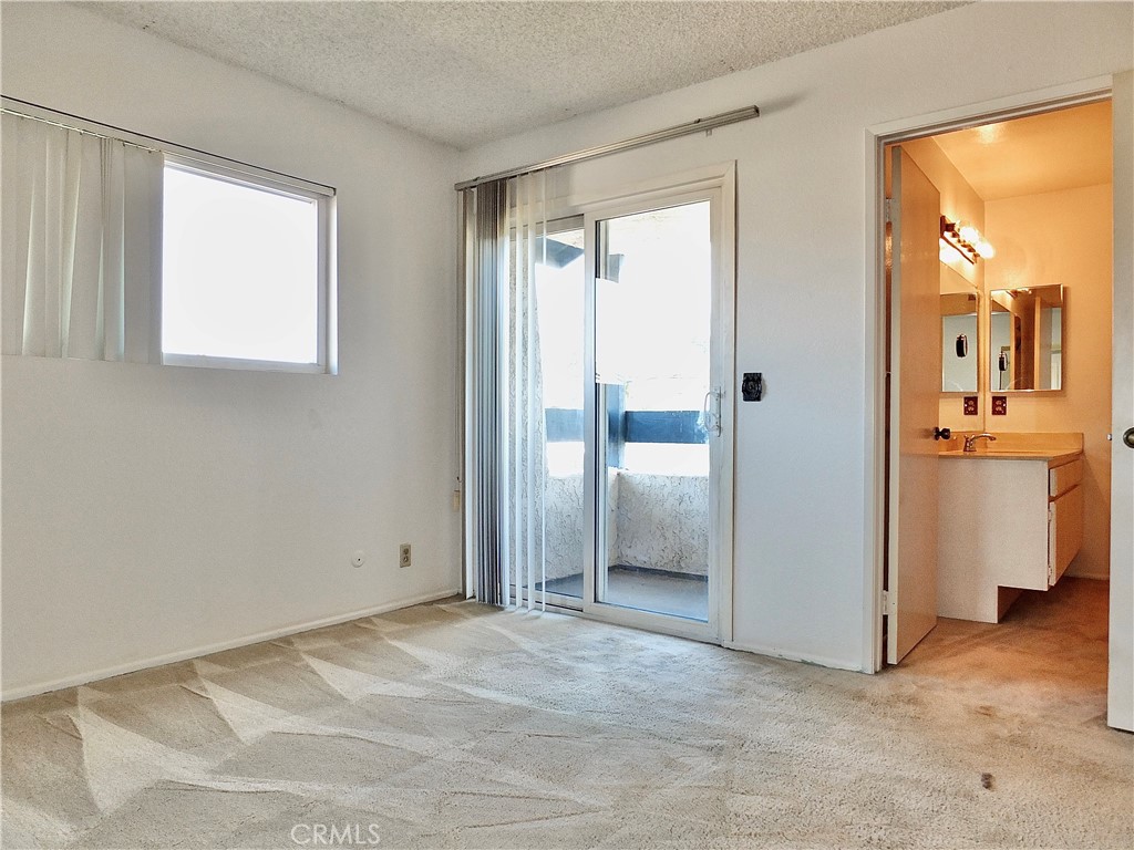 The primary bahroom is next to balcony. - 8485 Kington Way 11, Cypress CA 90630 - photo 20