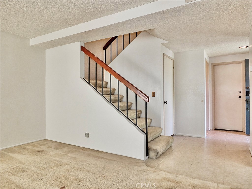Acess to the garage door is to the right of the stairs and the front door. - 8485 Kington Way 11, Cypress CA 90630 - photo 31