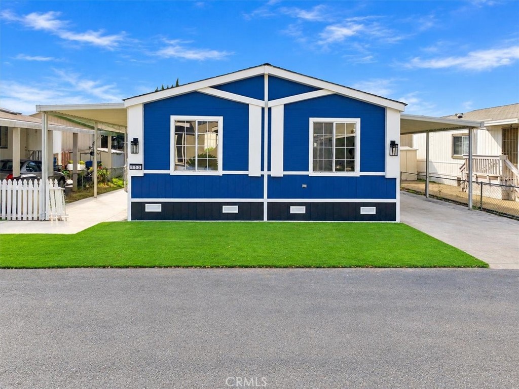 Front view of the home on an oversized lot, with new turf and covered parking on both sides. - 9080 Bloomfield Avenue 153, Cypress CA 90630 - photo 2